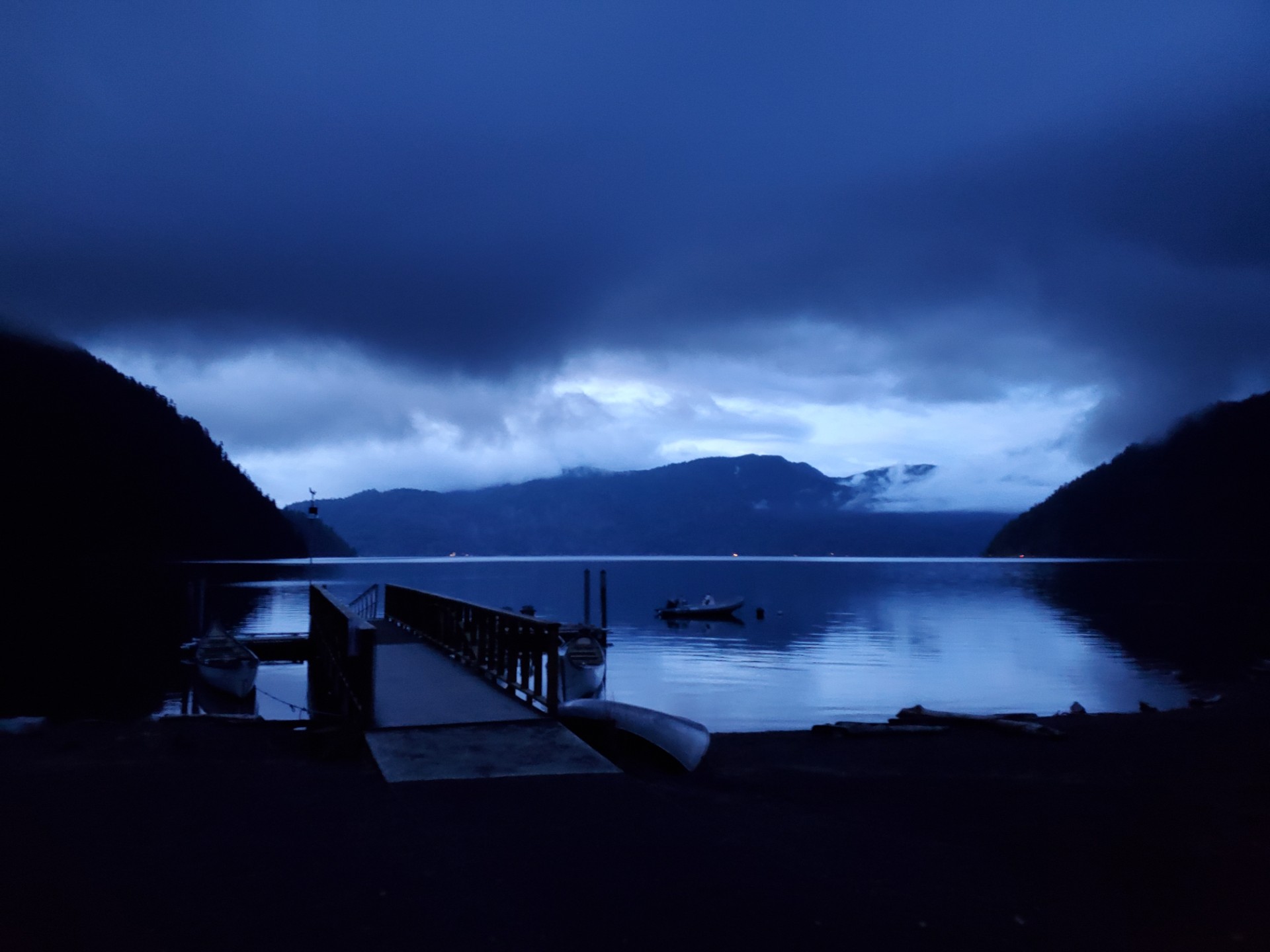 Scene of boat and dock on a lake at night.