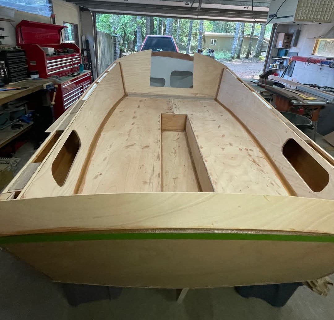 Interior of a wooden boat build in progress in a garage.